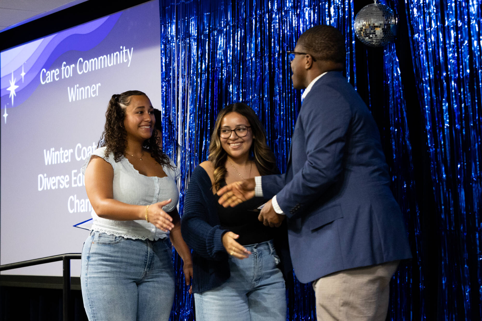 students shaking hands with advisor presenting award